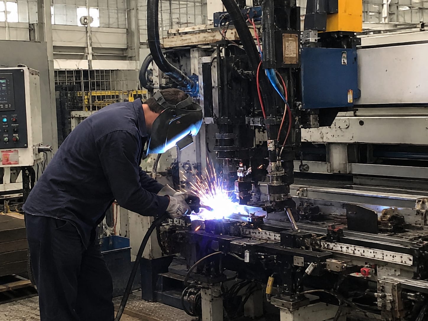 Profissional realizando soldagem em máquina industrial